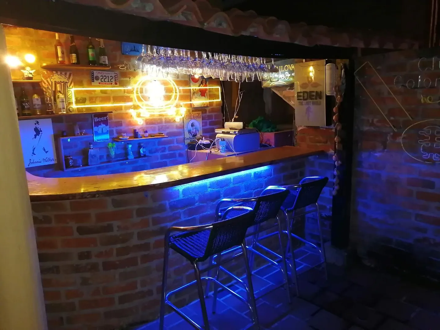 Bar del Hostal Campestre El Galeno con luces de neón y barra en ladrillo
