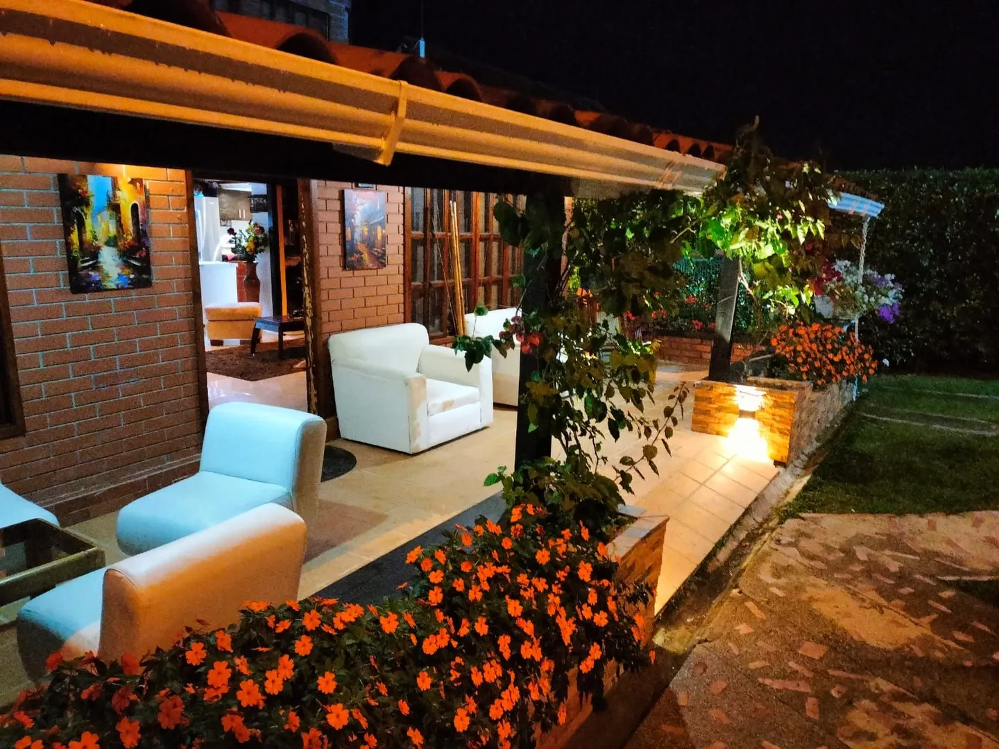 Corredor con sillas y flores en el jardín del Hostal Campestre El Galeno
